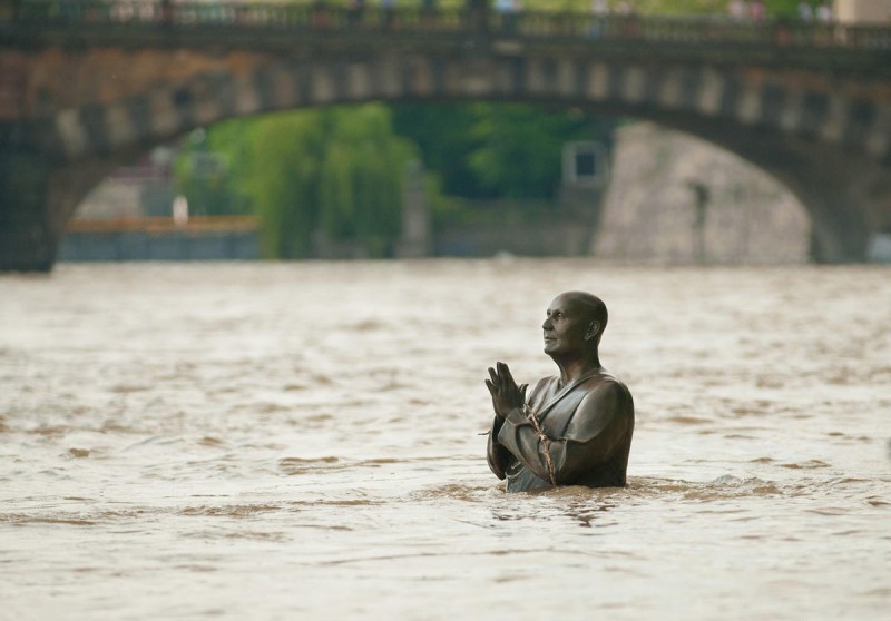Скульптура молящегося человека под водой